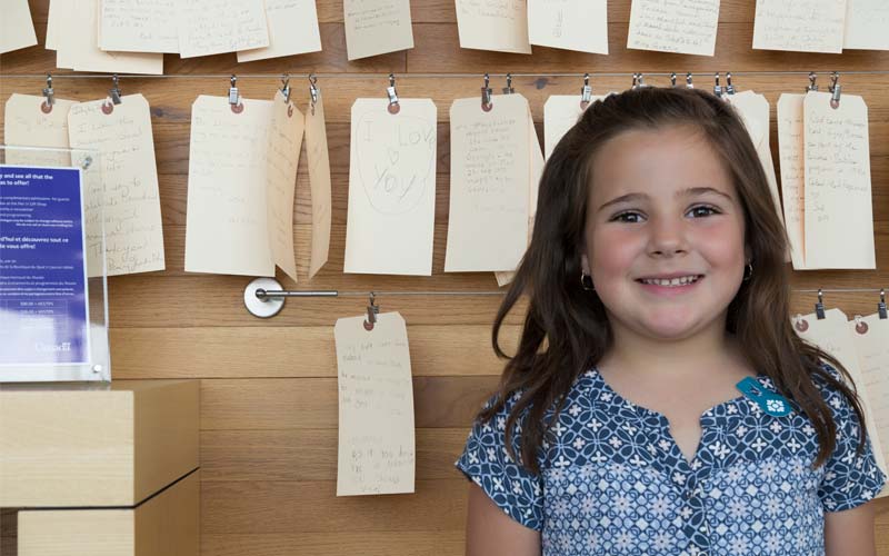 A young girl stands in front of an exhbit