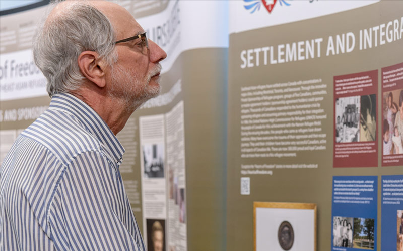 A man reads an exhibition panel.