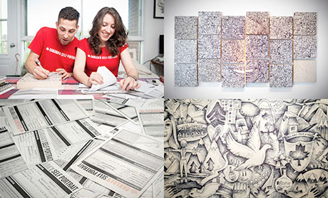 A young man and woman wearing red tee shirts are happy as they look at lots of papers spread out on a table. The other side shows artwork on the wall.