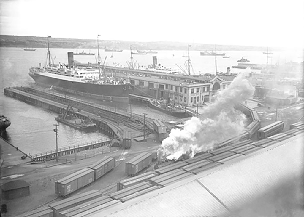 View of a harbour with several large ships dotted throughout.