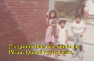 Three small children stand in front of a building.