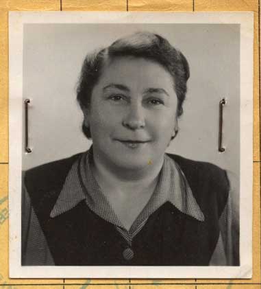 Old head shot photo attached on a paper with pins of a young woman.