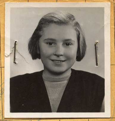 Old head shot photo attached on a paper with pins of a young woman.