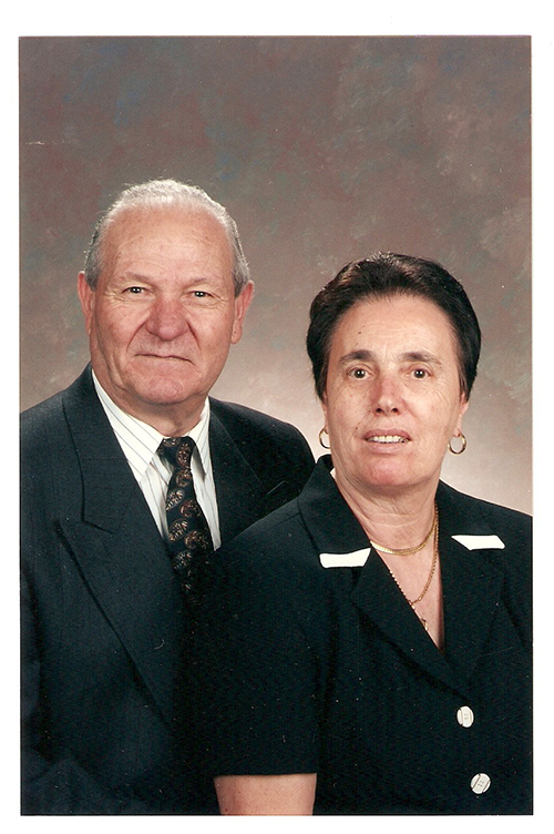 Beautiful couple sitting next to each other for a photo.