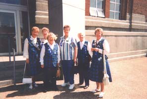 Audrey standing outside Pier 21 Museum with five women dressed in tartan.