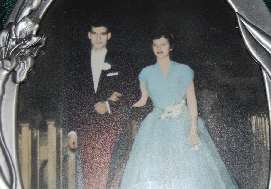 A picture frame with a photo of a couple in formal clothes on their wedding day.