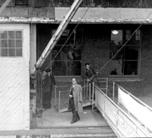 Man walking off ramp of ship.