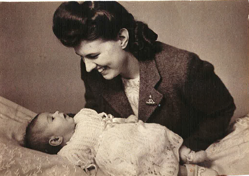 This is my mother Edith Wallace (nee Metcalfe), and me (Susan Margaret) in May 1946. I was 3 months old. My mother is wearing the artillery pin which my father gave her after their wedding. The pin was called a “sweetheart brooch”. My mother knitted her sweater (in yellow) and my Christening dress (in white wool, same pattern as her sweater)