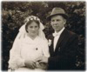 A married couple are holding handsand standing for a photo.