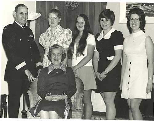 A group of family members are standing around a young woman.