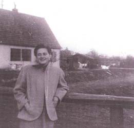 Karen as a young woman, leaning against a fence.