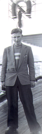 Young Mels standing on the deck of a boat.