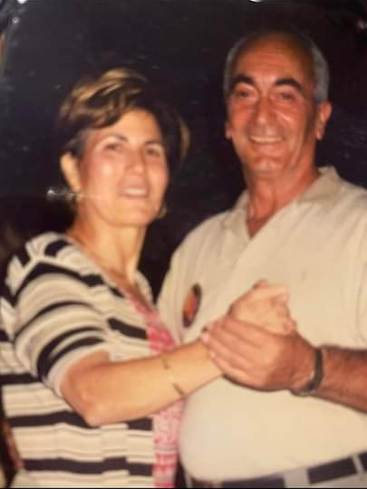 A man and a woman dancing and smiling at the camera.