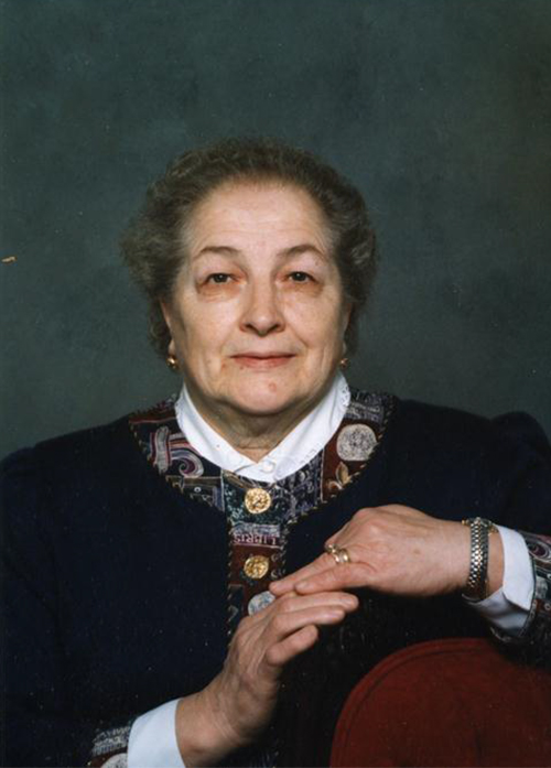 Headshot photo of beautiful lady putting hand on maroon and black object.