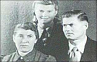 Family portrait of mother, father and daughter standing behind them.