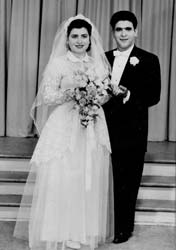 Young bride and groom on wedding day, in front of steps.