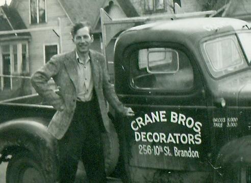 Black and white photo of a white man standing with a truck that says Crane Bros Decorators.